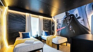 Habitación de hotel con dos camas, un mural grande en la pared e iluminación moderna.