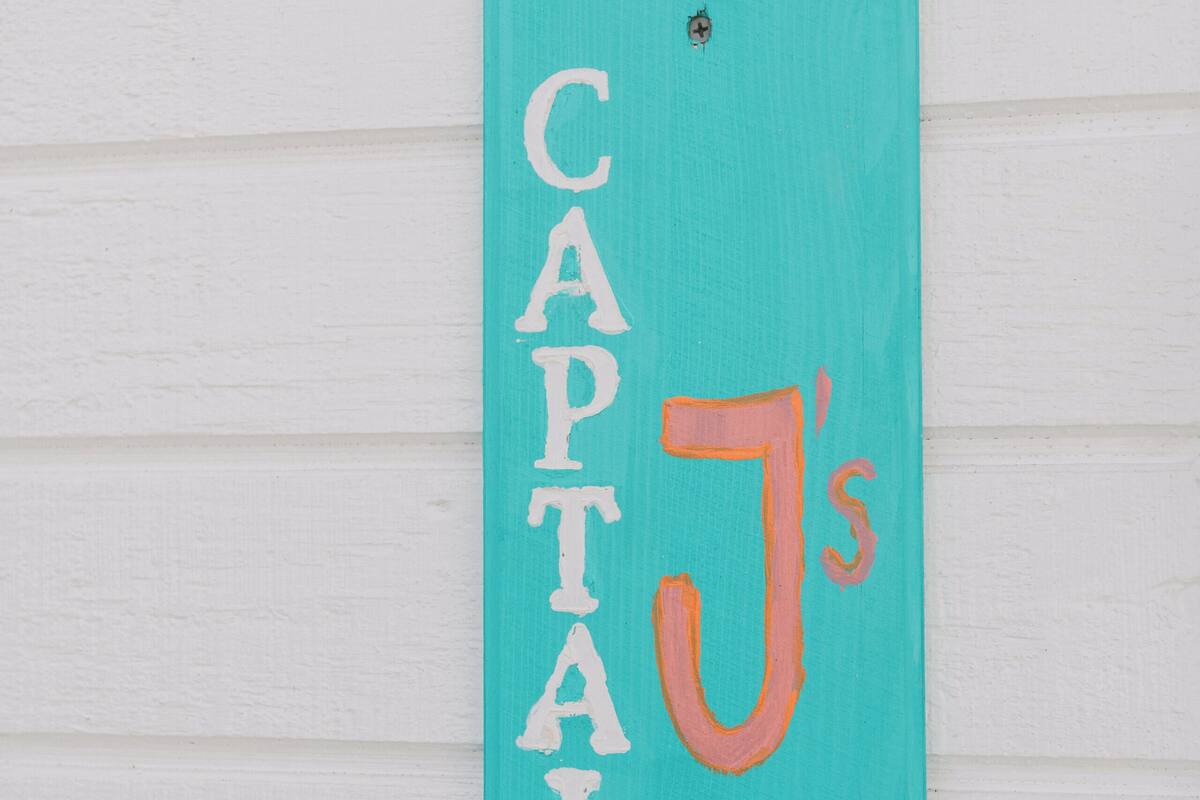 A teal sign with the number 2 and the text "CAPTAIN J's" on a white wall.