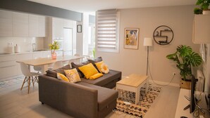 A modern living room with a grey sofa, a wooden coffee table, and a dining area with a white table and chairs. - Cool Vialia (Vigo)