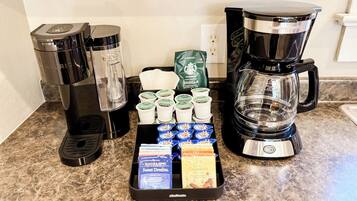 A coffee station with multiple coffee makers and a variety of coffee pods.