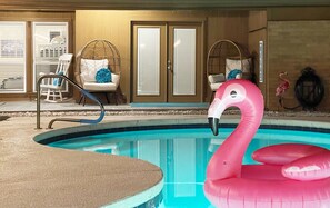 A swimming pool with a pink flamingo float, a chair with a blue pillow, and a door with a frosted glass panel. - Pet-friendly 4-bedroom + Pool (Richardson)