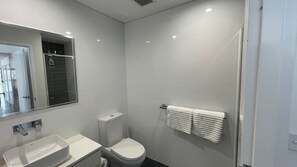 A modern bathroom with a toilet, sink, and a towel rack. - Charming 2-Bedroom Unit with Stunning Back Creek Views (South West Rocks)