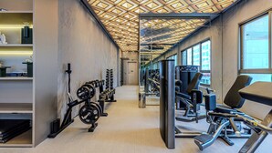 Een moderne sportschool met gewichthefapparatuur, loopbanden en een versierd plafond.