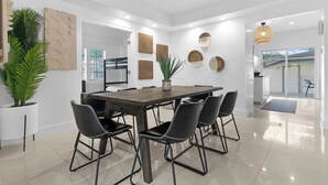 A modern dining area with a large table, six chairs, and decorative wall art. - 7BD Downtown Oasis Pool  (Miami)