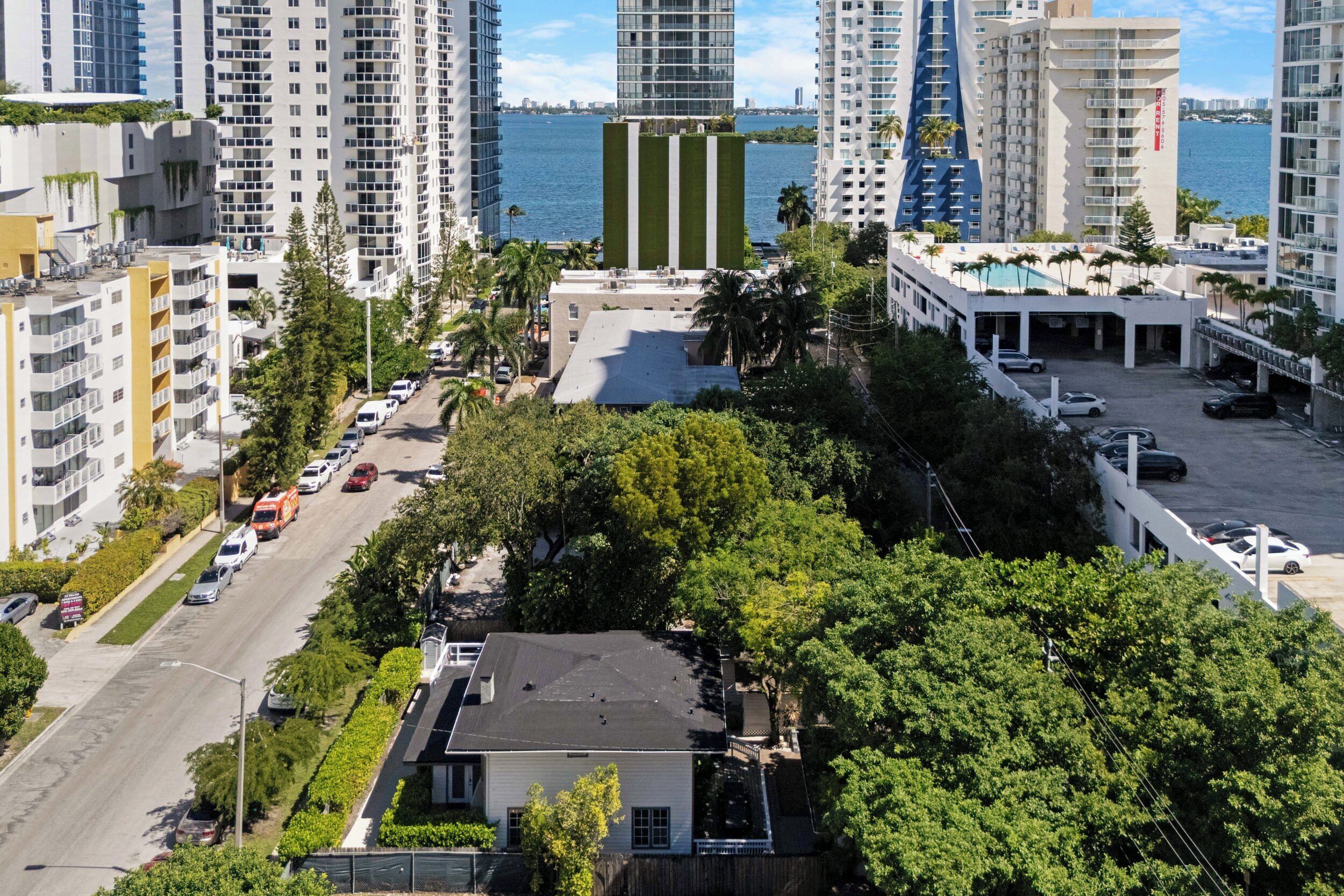A high-rise building with a view of the water and other buildings.