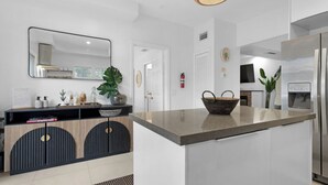 A modern kitchen with a central island, a built-in oven, and a stainless steel refrigerator. - 7BD Downtown Oasis Pool  (Miami)