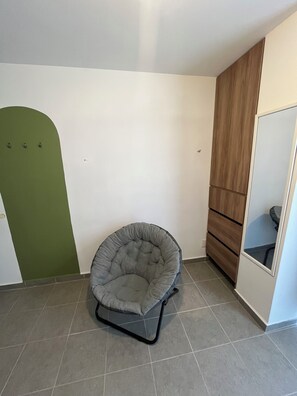 A room with a grey bean bag chair, a green door, and a wooden cabinet. - Private room in Colonia Roma Norte. (Ciudad de México)