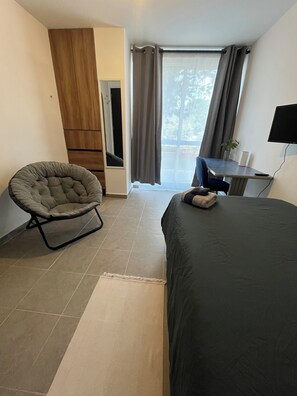 A hotel room with a bed, a chair, a desk, and a TV. - Private room in Colonia Roma Norte. (Ciudad de México)