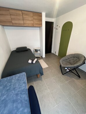 A small, modern room with a bed, a chair, and a table. - Private room in Colonia Roma Norte. (Ciudad de México)