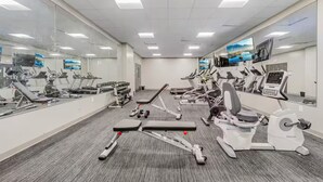 A gym with various exercise equipment, mirrors, and a carpeted floor. - DT · Fast Wifi · Pet Friendly · Bidet Sprayer (Cleveland)