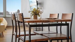 A dining area with a wooden table and chairs, a potted plant, and a framed picture on the wall. - DT · Gym · Pet Friendly · 1 Bus to Clinic or CSU (Cleveland)