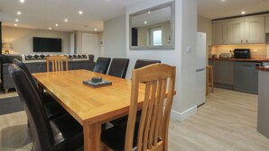 A modern kitchen with a dining area. - Caledfryn (Tyn-y-Gongl)