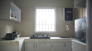 Una cocina con ventana, estufa, fregadero y microondas.