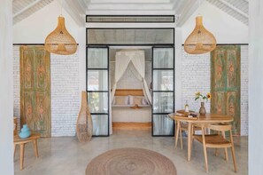 A room with a bed, a dining table with chairs, and a hanging light fixture. - Private Pool Villa in Bisma, Ubud Super-walkable (Ubud, Kecamatan Ubud, Kabupaten Gianyar)