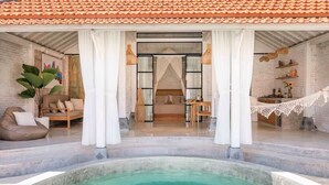 Un área de spa lujosa con piscina, un rincón de descanso acogedor y un dormitorio con vista a la piscina.