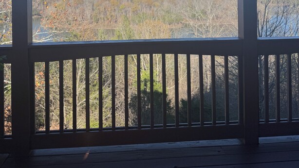 A wooden deck with a view of a forested landscape. - DERBY SPECIAL  includes parking spot 50 ft from the track . 6-bedroom lodge (Bloomfield)