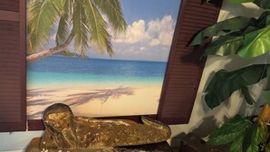 A framed tropical beach mural with a golden statue of a reclining figure. - DERBY SPECIAL  includes parking spot 50 ft from the track . 6-bedroom lodge (Bloomfield)
