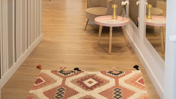 A modern living room with a sofa, a round table with a lamp, and a large mirror. There is a dining area in the background with a table and chairs. - Cozy Loriga (Vigo)