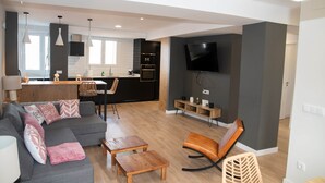 A modern living room with a grey sofa, wooden coffee table, and a TV mounted on the wall. - Cozy Loriga (Vigo)