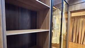 Ein Holzkleiderschrank mit mehreren Einlegeböden und einer Spiegel-Tür.