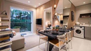 A modern kitchen with a dining area, a washing machine, and a large window overlooking a garden. - Red calllitr (Goiânia)