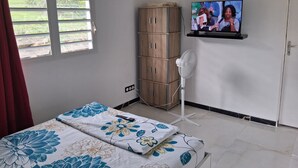 A bedroom with a bed, a wardrobe, a TV, and a window. - Espace Zen Bellevue (Sainte-Rose)
