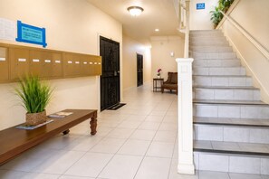 A hotel lobby with a reception desk, a staircase, and a set of lockers. - Chic & Stylish Studio Near Downtown LA * W/D * AC (Los Angeles)