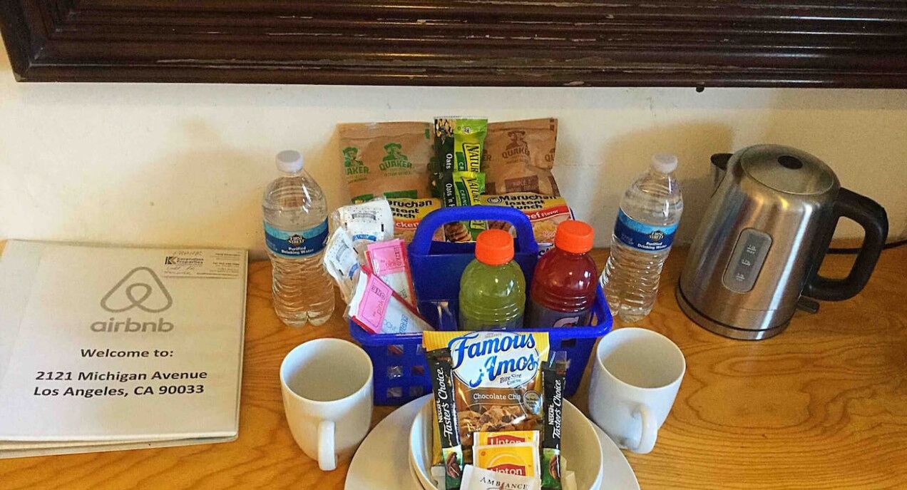 Ontbijt met een koffiezetapparaat, waterflesjes, een vruchtensapje en een doos Famous Amos chocoladereepjes.