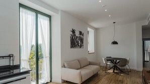 Een moderne woonkamer met een bank, eettafel en een keukenhoek.