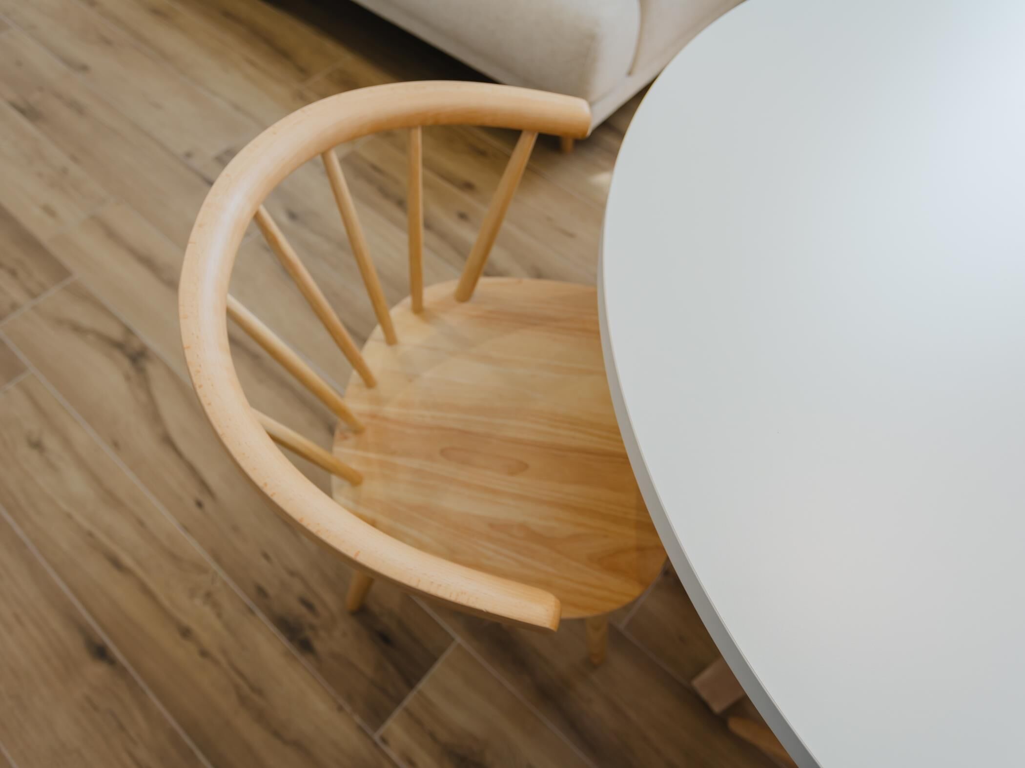 Une chaise en bois avec un dossier incurvé et une table ronde.