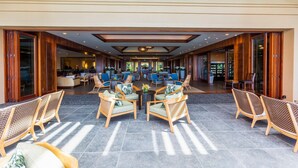 Un hall d’entrée spacieux avec un espace salon central, un comptoir d’accueil et une vue sur l’intérieur de l’hôtel.