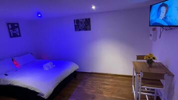 A room with a bed, a desk, and a TV.