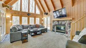 A cozy cabin interior with a stone fireplace, a large TV mounted above it, and a wooden ceiling. - Harbor Springs Lodge, Less then a mile to Nubs/Highlands
Ski,Golf, Hot Tub, (Harbor Springs)