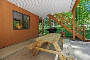 A wooden cabin with a picnic table, a grill, and a staircase leading to an upper level. - Harbor Springs Lodge, Less then a mile to Nubs/Highlands
Ski,Golf, Hot Tub, (Harbor Springs)