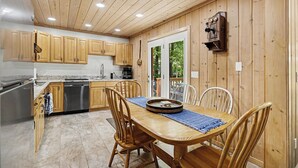 A kitchen with wooden cabinets, a stainless steel dishwasher, and a dining table with chairs. - Harbor Springs Lodge, Less then a mile to Nubs/Highlands
Ski,Golf, Hot Tub, (Harbor Springs)