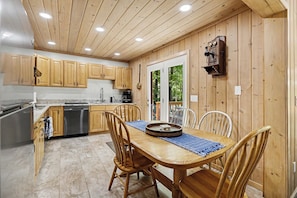 A kitchen with wooden cabinets, a stainless steel dishwasher, and a dining table with chairs. - Harbor Springs Lodge, Less then a mile to Nubs/Highlands
Ski,Golf, Hot Tub, (Harbor Springs)