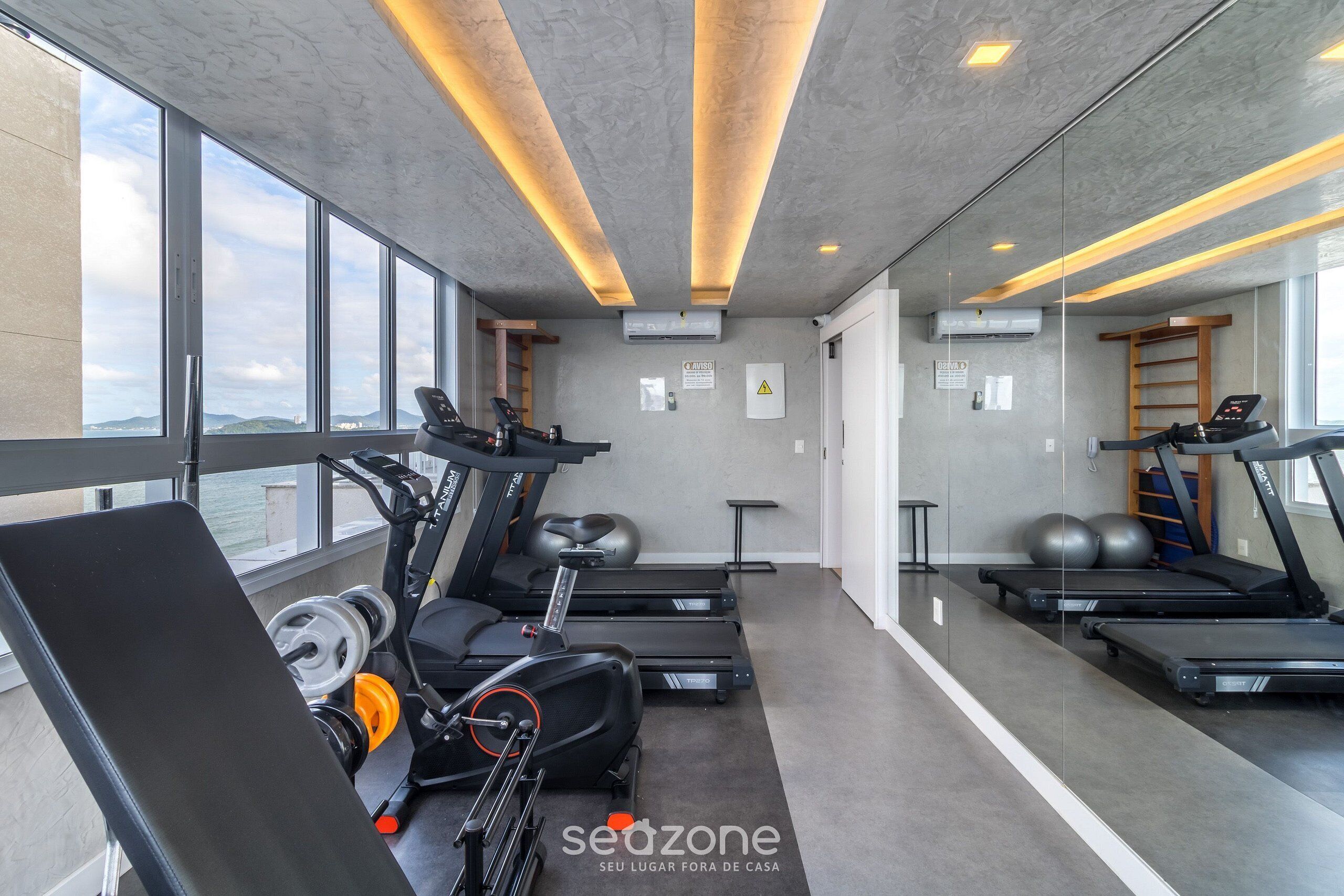 Un gimnasio con cintas de correr, pelotas de ejercicio y pesas.
