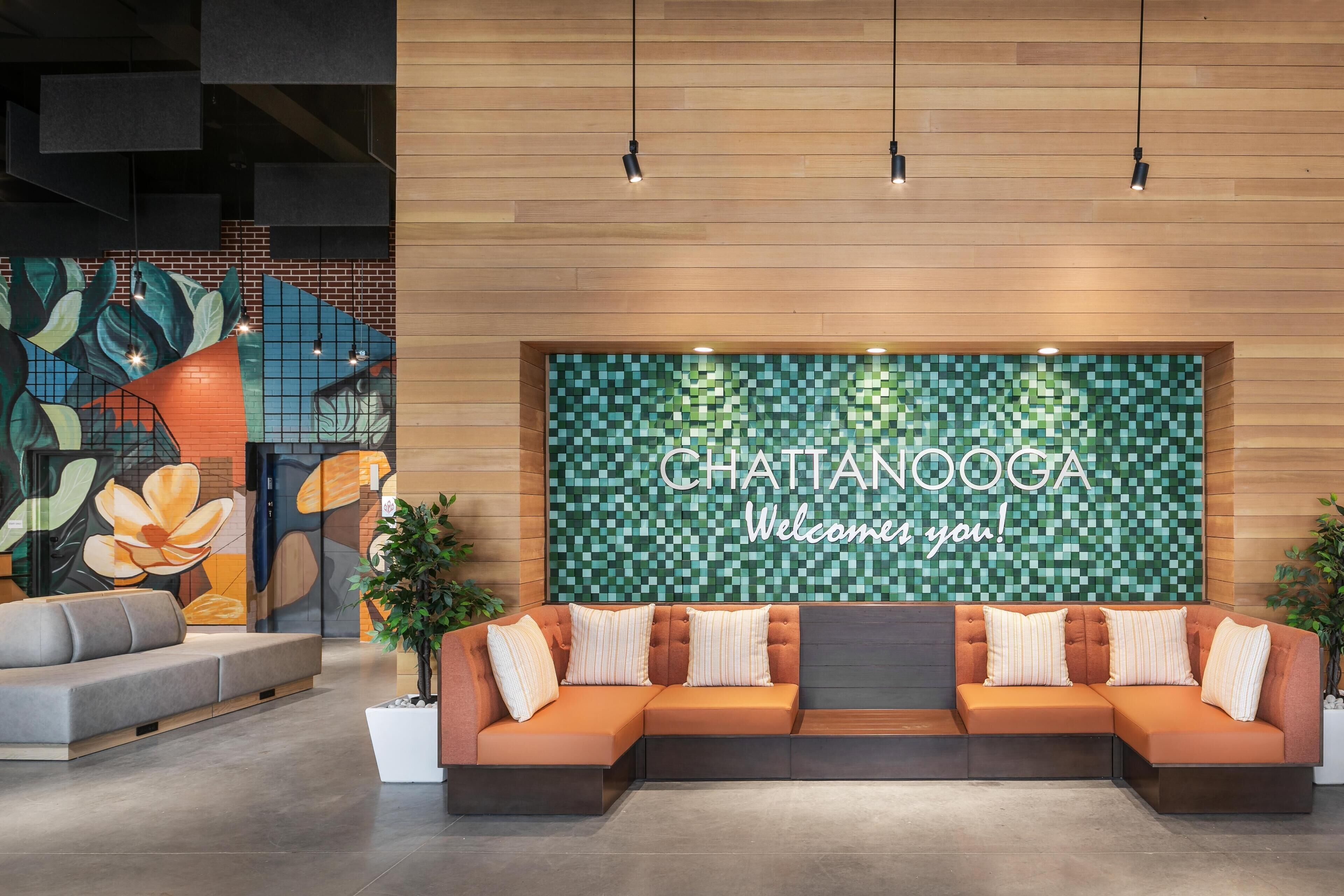 A reception area with a large welcome sign, a sofa, and a wall with a mosaic pattern.