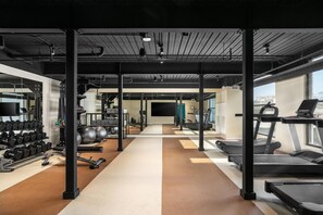 Ett gym med löpband, hantlar och träningsbollar.