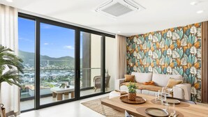 A modern living room with a large sliding glass door leading to a balcony, a dining area with a wooden table, and a patterned wall. - D434 - Amazing Apartment with Balcony (Sint Maarten)