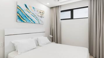 Una habitación de hotel moderna con una cama grande, un aire acondicionado instalado en el techo, una ventana con cortinas y una obra de arte abstracta en la pared.