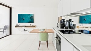A modern kitchen with a dining area, a large window, and a view of the sea. - D416 – Relaxing apartment with Balcony (Sint Maarten)