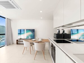 A modern kitchen with a dining area, a large window, and a city view. - C345 – Modern Lagoon Escape (Sint Maarten)