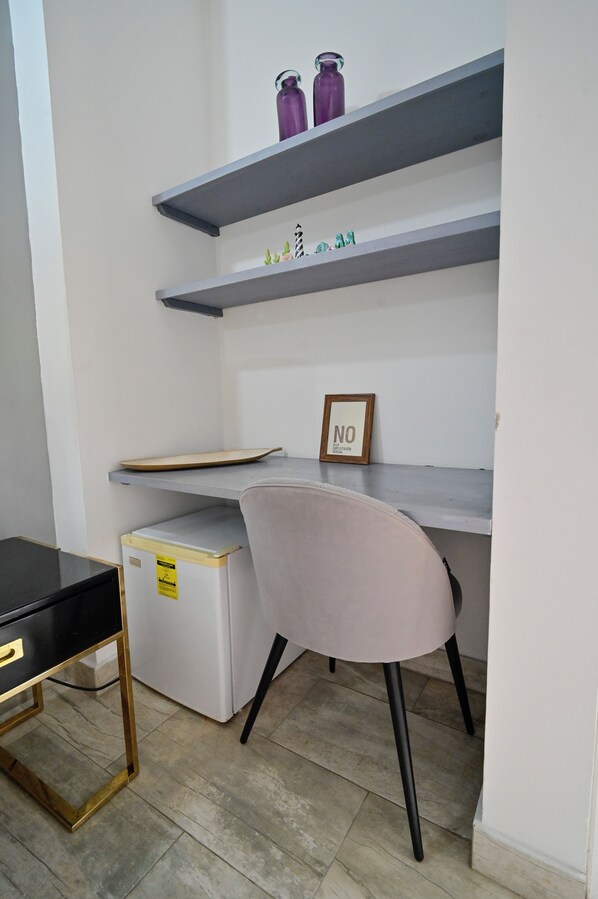 A compact workspace with a desk, chair, and shelving unit.