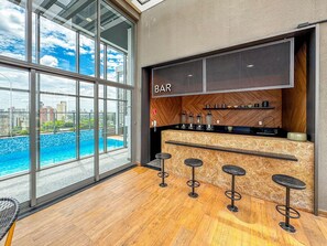 A bar area with a city view, a wooden floor, and a modern design. - AD330 - 1002 (São Paulo)