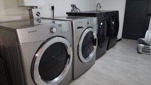 Et vaskerum med to Frigidaire frontbetjente vaskemaskiner og en Samsung tørretumbler.