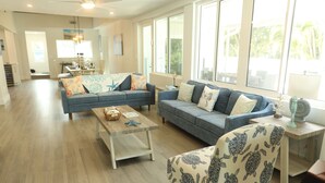 A spacious living room with two sofas, a coffee table, and a patterned armchair. - Lakefront Oasis w/ Heated Pool 2-Minutes Walk to Beach! (Holmes Beach)