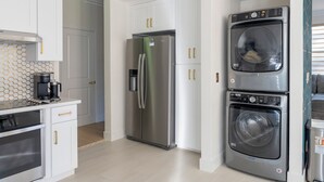 A compact kitchen with a stainless steel refrigerator, a built-in washer and dryer, and a coffee maker on the countertop. - Beautiful 2-bedroom condo in cool San Diego close to the mall! (San Diego)