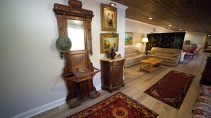 A living room with a wooden floor, a sofa, a coffee table, and a large mirror. - Spacious Beautiful Unique place to stay in Morganton, NC. (Morganton)