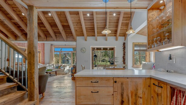 A spacious kitchen with wooden cabinets, a large island, and a view of the outdoors. - A Serene Mountain Autumn/Fall Getaway (Soda Springs)